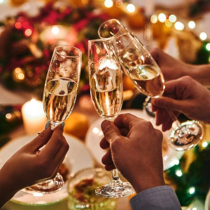 Grupo de pessoas brindando em confraternização de fim de ano, simbolizando celebrações e convivência social