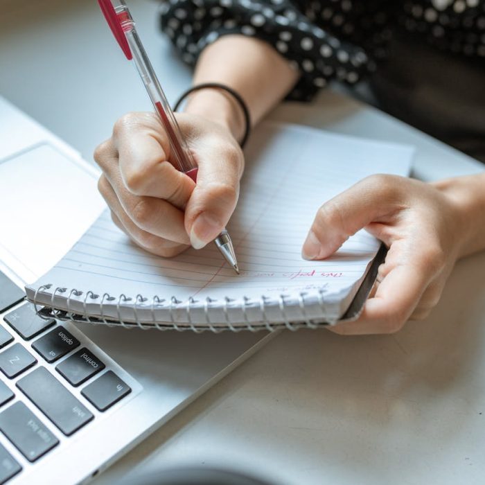 Mulher escrevendo em papel representando planejamento jurídico, reflexão e tomada de decisões conscientes